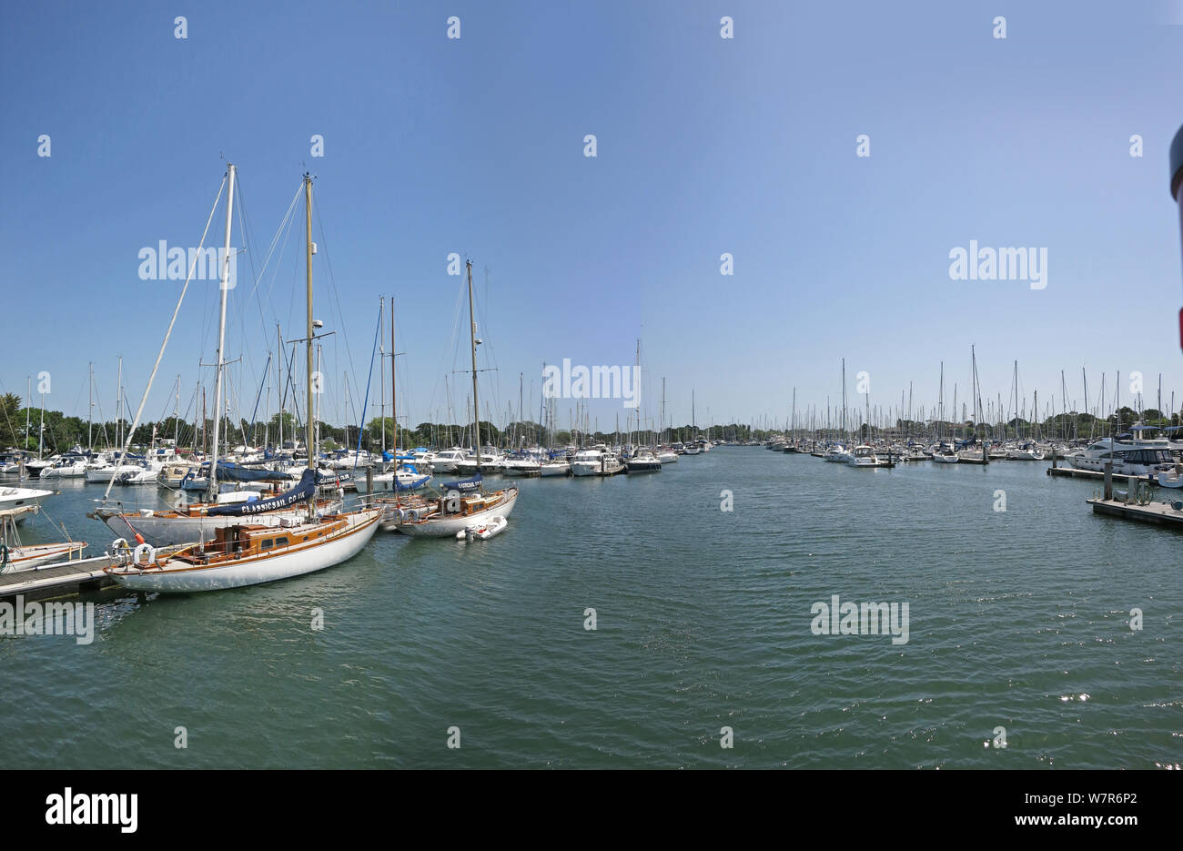 Chichester Yacht Basin, a purpose-built marina on Chichester Harbour, West Sussex, UK. Shows vintage yachts (left), main channel and mooring pontoons. Stock Photo