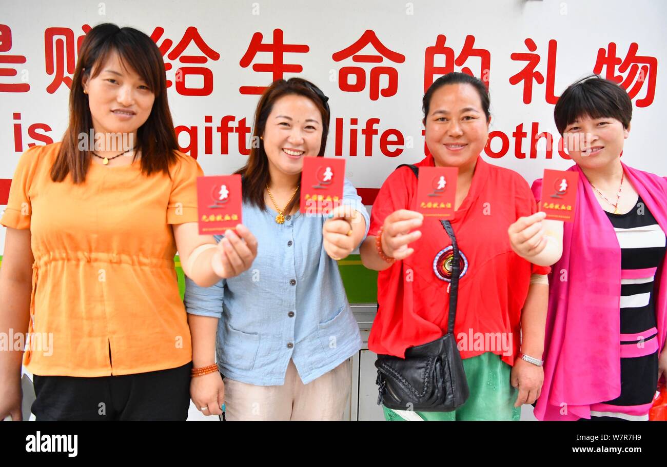 Chinese citizens show their blood donor cards to mark the 14th World