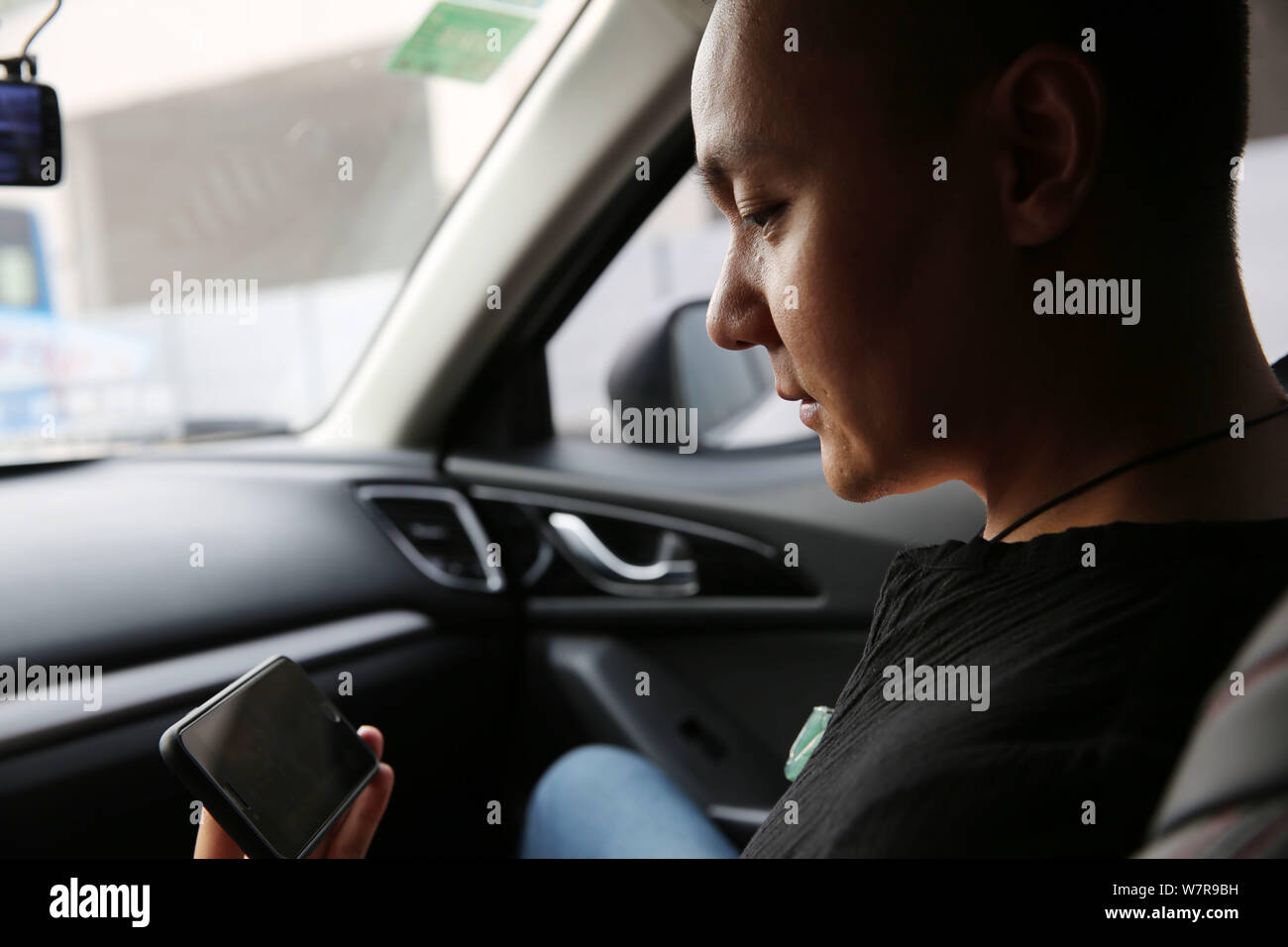 39-year-old Chinese dance instructor Li Bei looks at his smartphone to watch dancing videos in Xi'an city, northwest China's Shaanxi province, 15 June Stock Photo