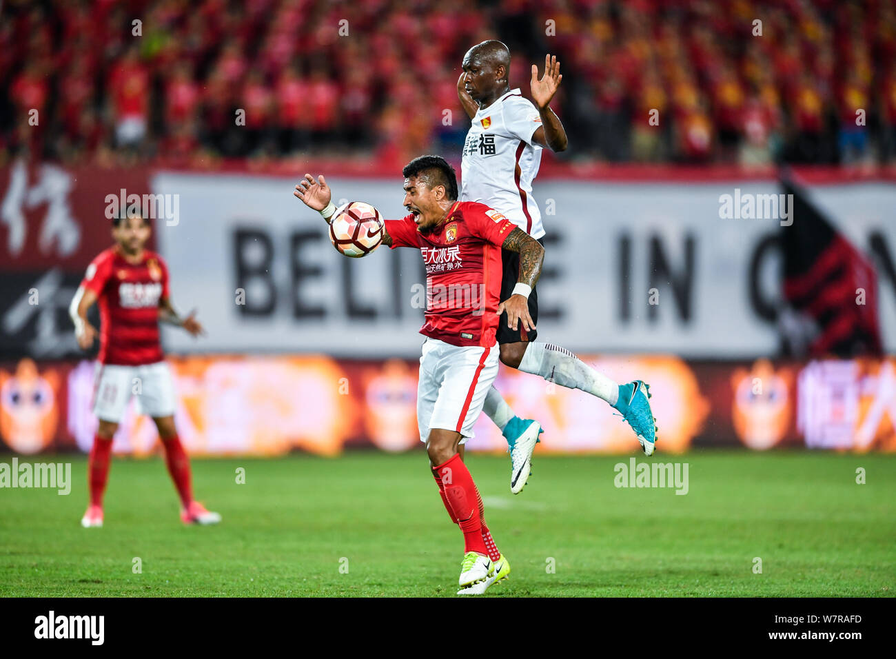 Brazilian football player Paulinho, below, of Guangzhou Evergrande Taobao, challenges Cameroonian soccer player Stephane Mbia of Hebei China Fortune i Stock Photo