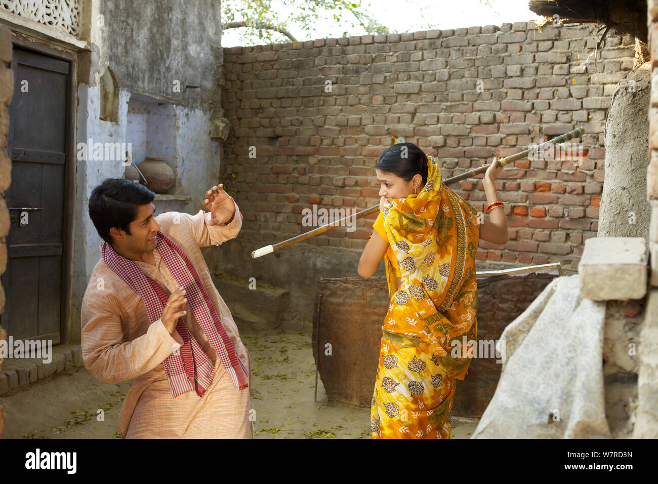 Rural woman hitting husband with cane Stock Photo