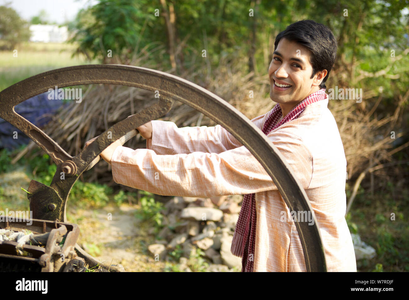 Farmer using fodder cutter and smiling Stock Photo - Alamy