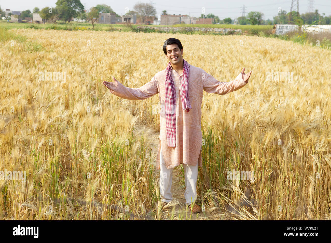 Farmer showing his field and smiling Stock Photo - Alamy