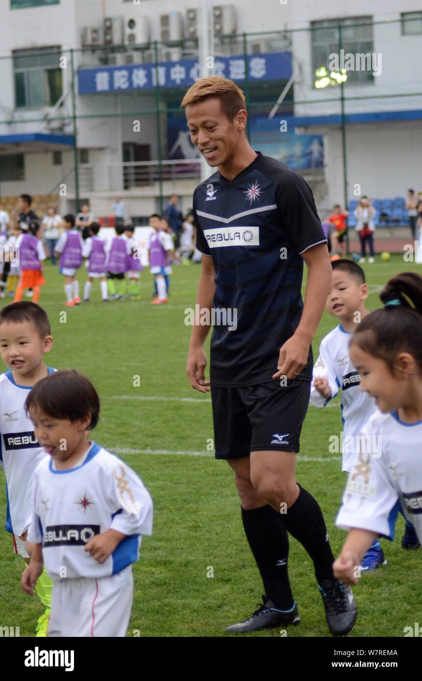 Japanese football player Keisuke Honda of A.C. Milan instructs young