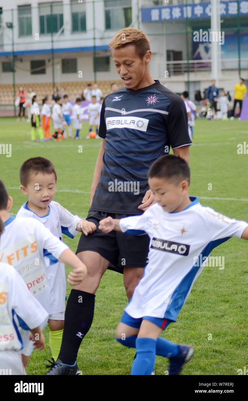 Japanese football player Keisuke Honda of A.C. Milan instructs young children during a youth football program in Shanghai, China, 15 June 2017. Stock Photo