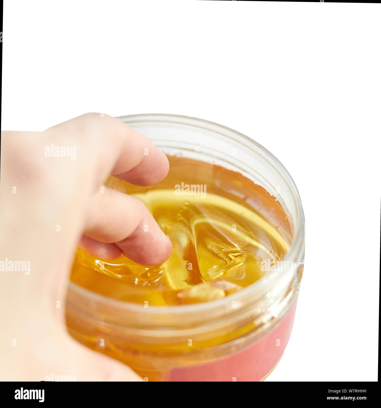 female hand picks sugar paste for jug shugaring from a jar. Close up Stock Photo