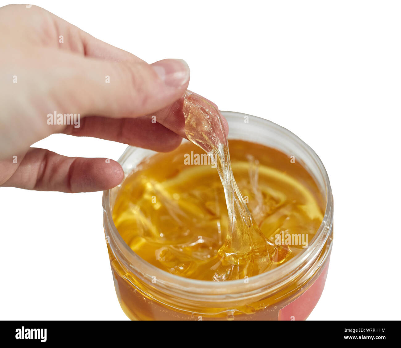 female hand pulls sugar paste for shugaring from a jar, kneads it. Close up. Stock Photo