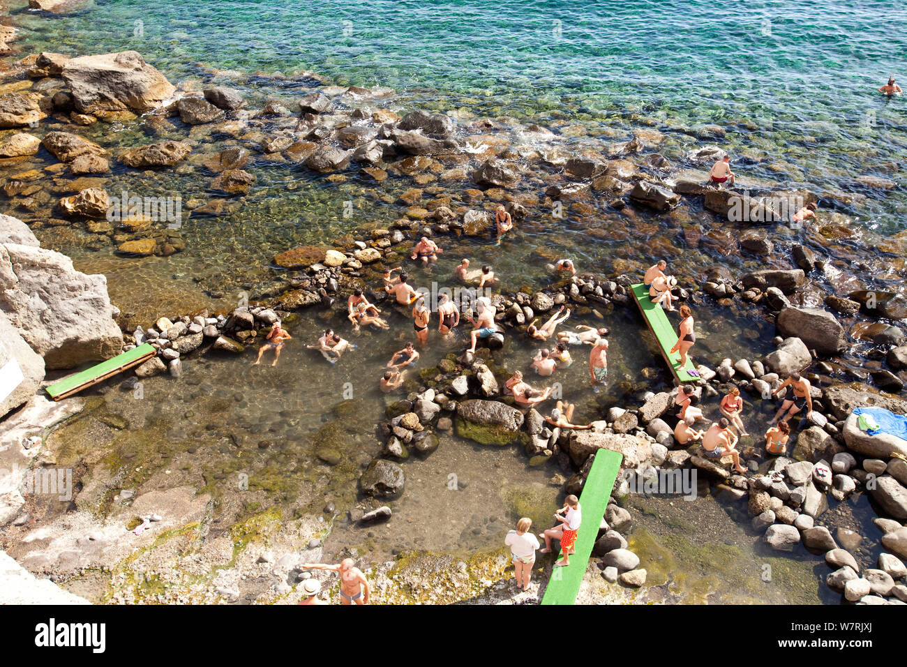 Tourists take a bath in the hot springs at Baia di Sorgeto, Ischia Island, Italy, Tyrrhenian Sea, Mediterranean Stock Photo