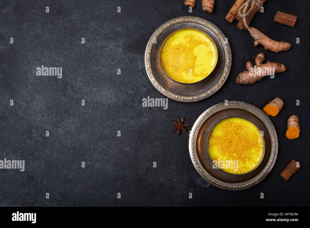 Golden turmeric milk on the black background with ingredients Stock Photo
