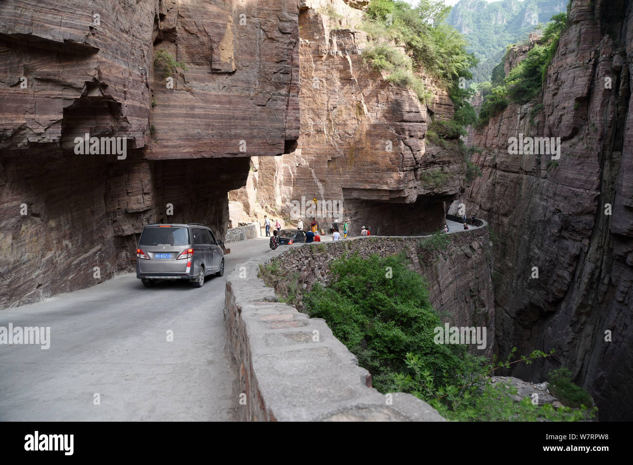 Tourists and buses pass along the Guoliang Tunnel through the Wanxian Mountain in the Taihang Mountains in Huixian county, Xinxiang city, central Chin Stock Photo