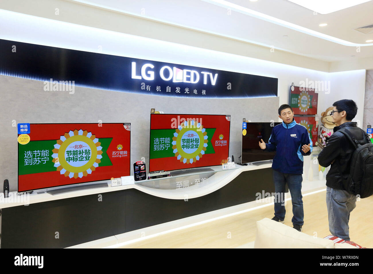 A Saleman Introduces An Oled Tv To A Customer At A Lg Store In