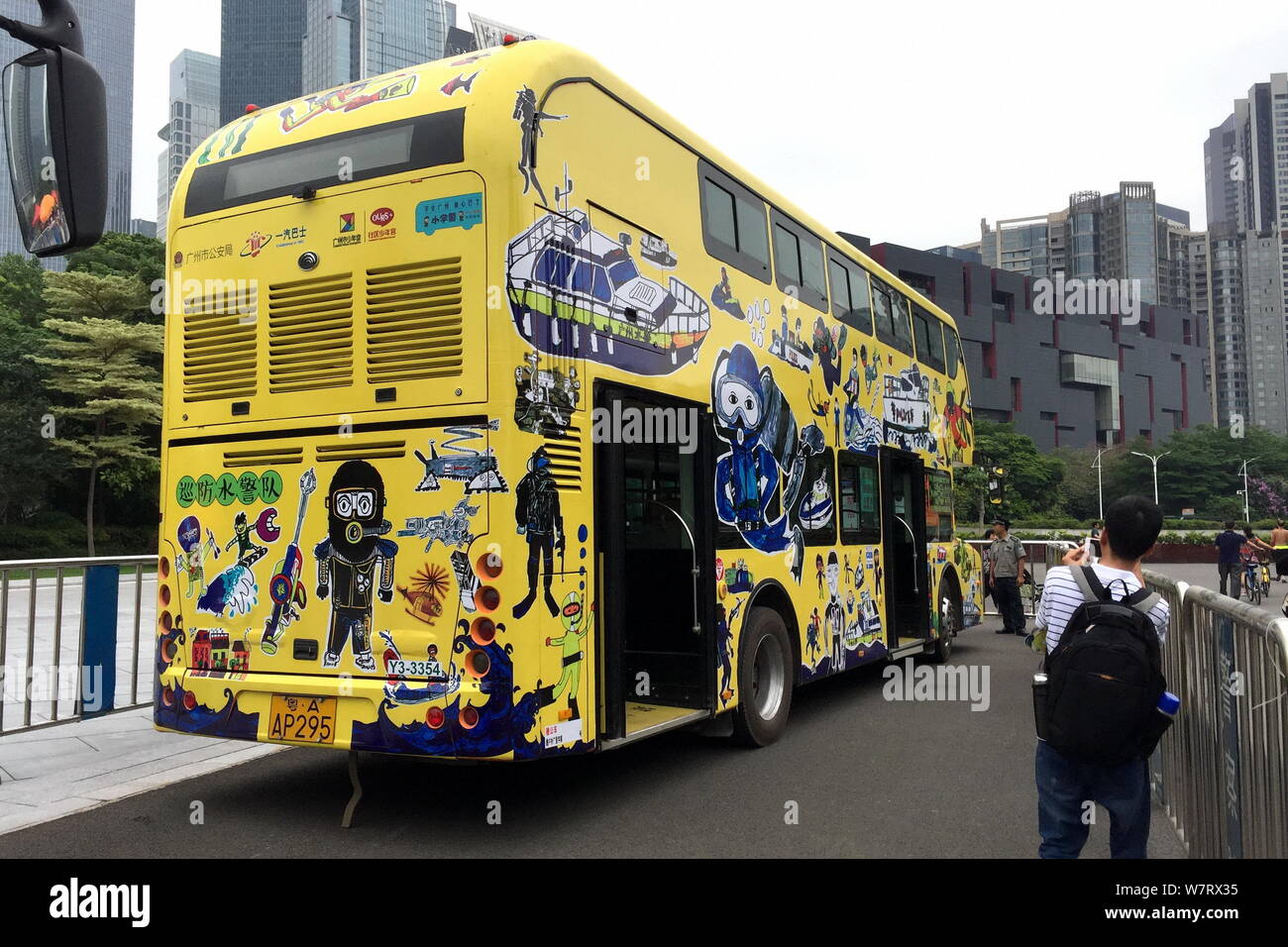 A local takes photos of a police-themed bus painted by 75 children ahead of the International Children's Day in Guangzhou city, south China's Guangdon Stock Photo