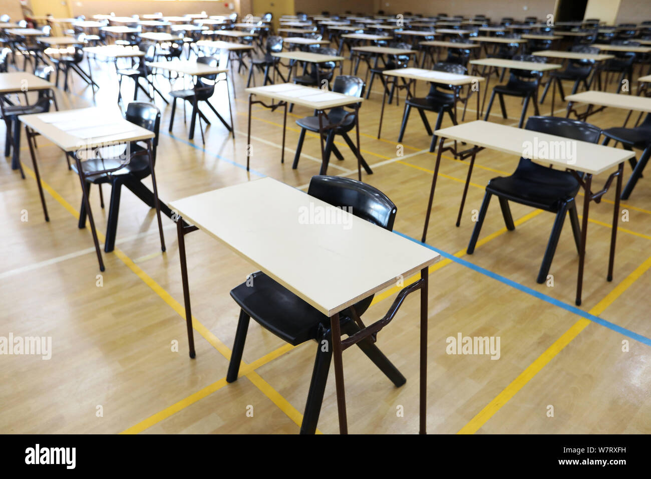 view of an exam examination room or hall set up ready for students to sit test. multiple desks tables and chairs. Education, school, student life conc Stock Photo