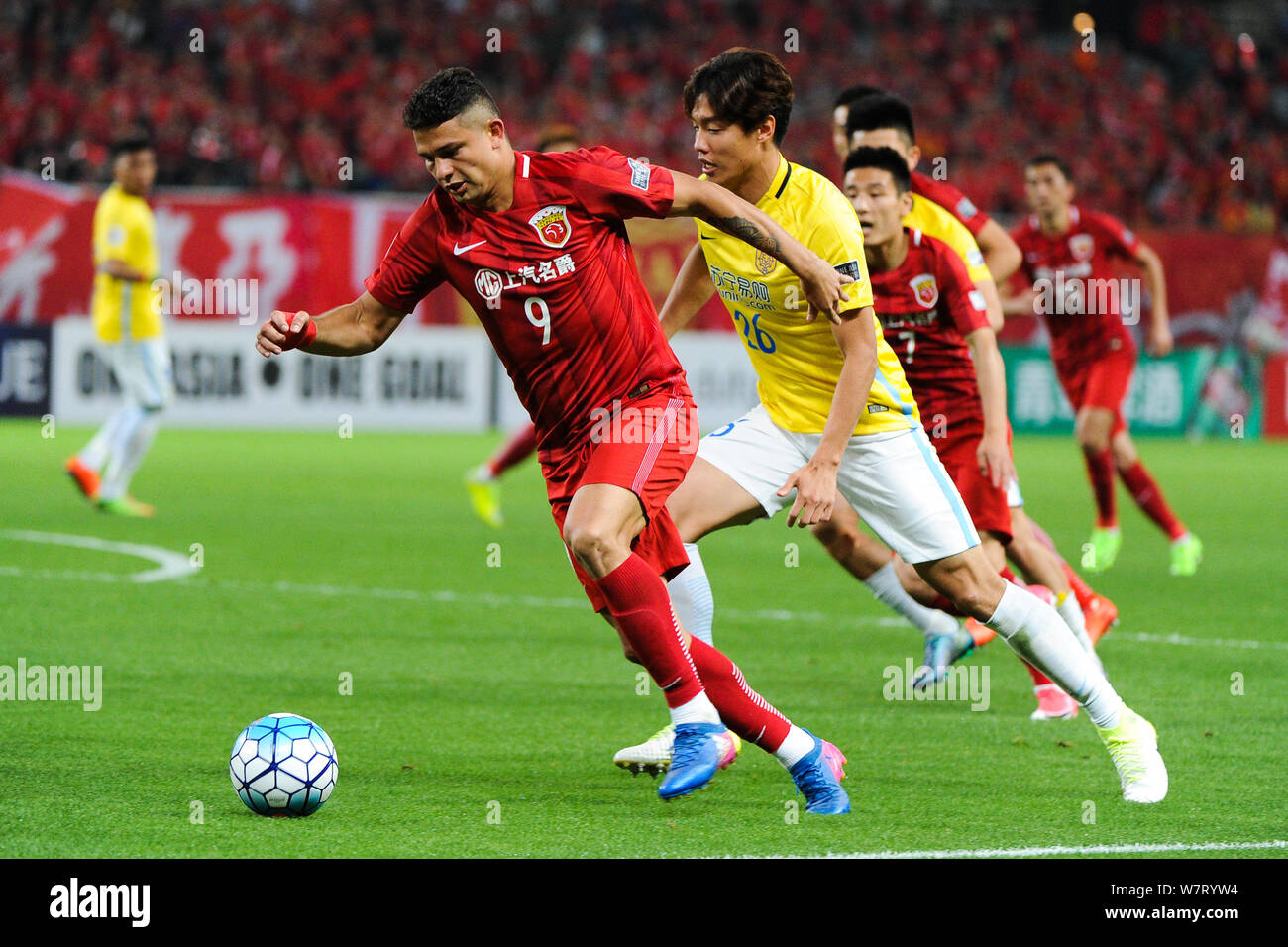Brazilian football player Elkeson of China's Shanghai SIPG, left, challenges South Korean football player Hong Jeong-ho of China's Jiangsu Suning in t Stock Photo