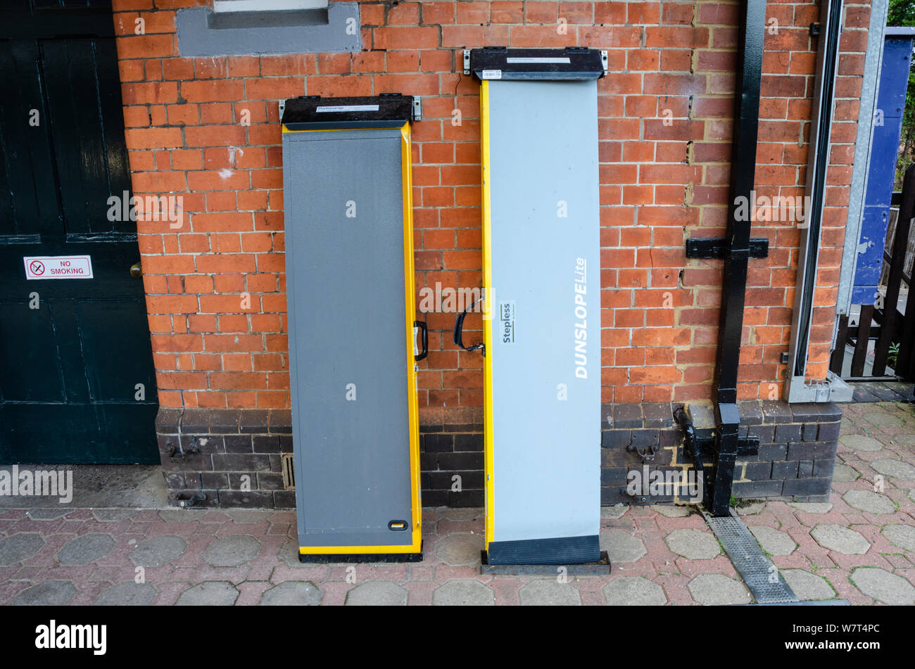 Ramps for helping wheelchair users on and off trains lean up against a wall at Pangbourne Railway station in West Berkshire, UK Stock Photo