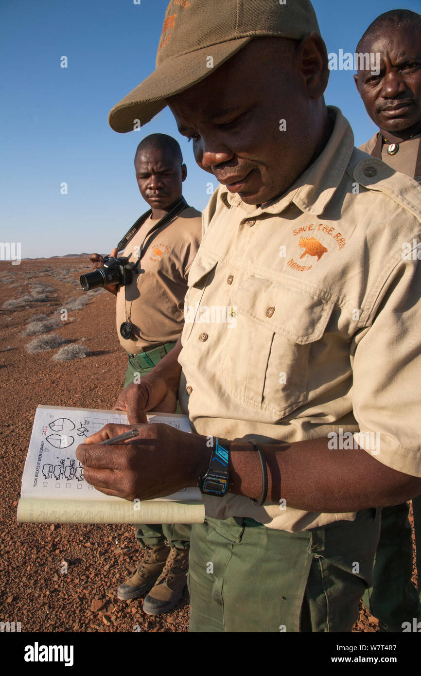 Save the Rhino Trust trackers Denso Tjiraso,  Martin Nawaseb foreground and Epson Rukama at Desert Rhino Camp, Wilderness Safaris, Kunene region, Namibia, May 2013 Stock Photo