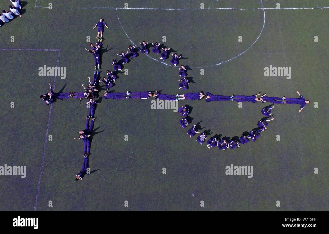 Students pose for a graduation photo featuring the shape of sine function on the playground of Tianjin Tanggu No.1 Middle School in Tianjin, China, 9 Stock Photo