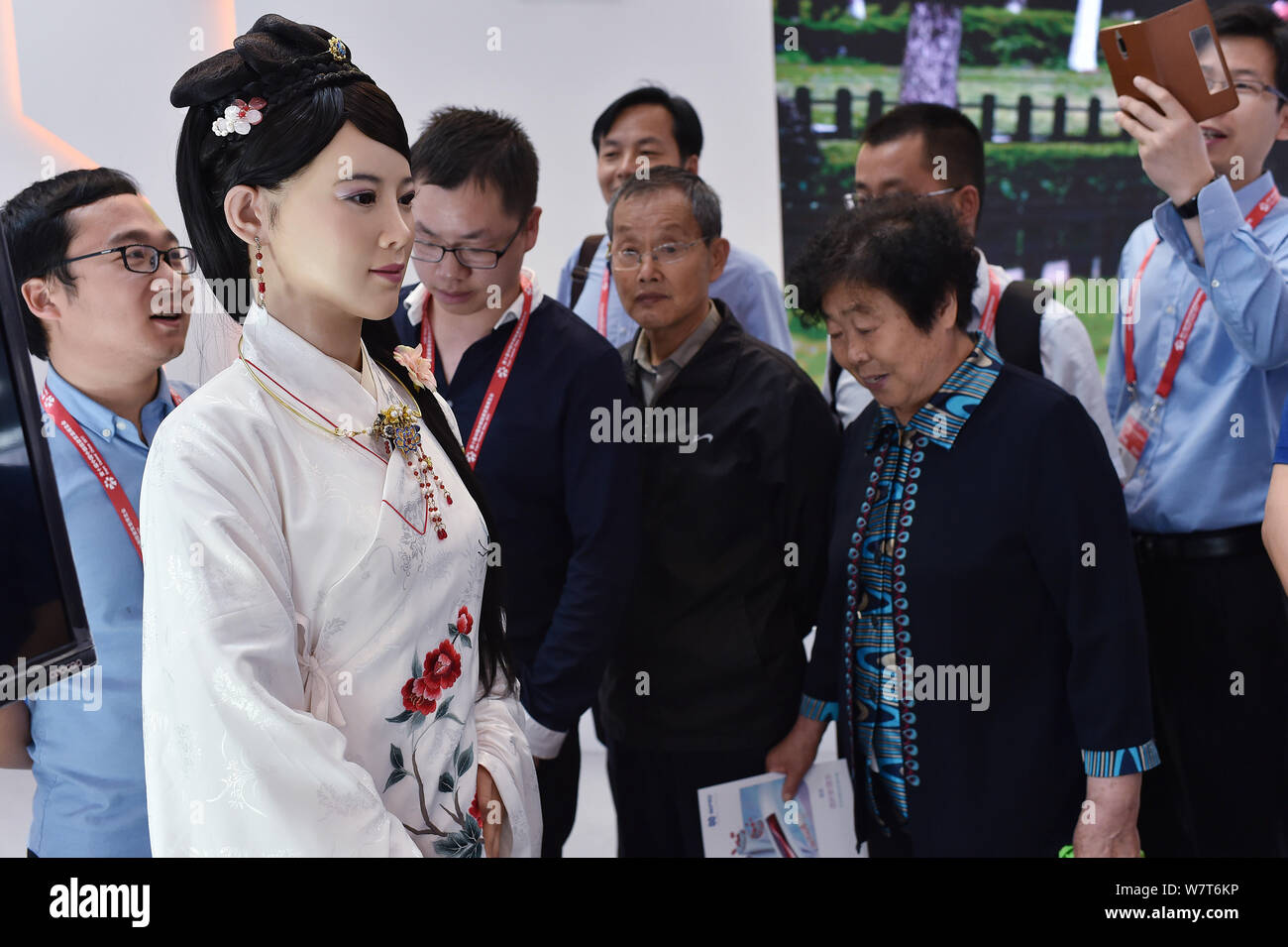 China's first advanced interactive robot Jia Jia, second left, interacts with visitors at the 10th Central China Investment and Trade Expo (Central Ch Stock Photo