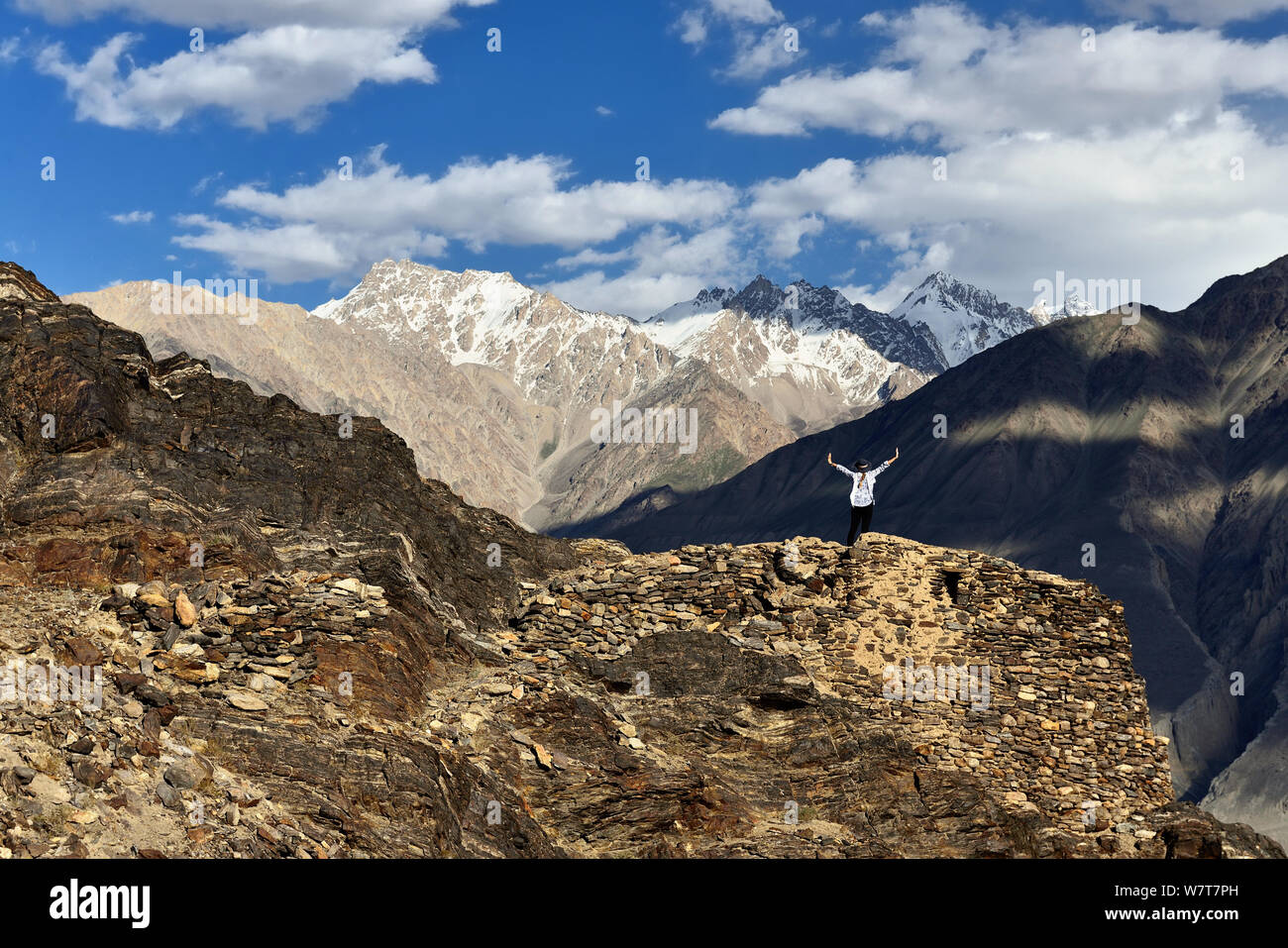 View on the Wakhan Valley in the Pamir mountain, Tourist standing on ruins of the Yamchun Fort looking on the white Hindu Kush range in Afghanistan, T Stock Photo