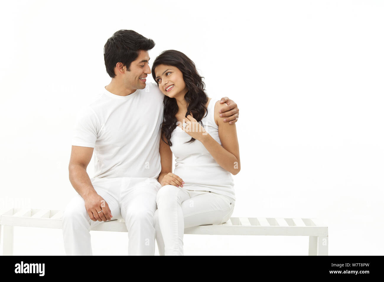 Young couple sitting on bench and smiling Stock Photo