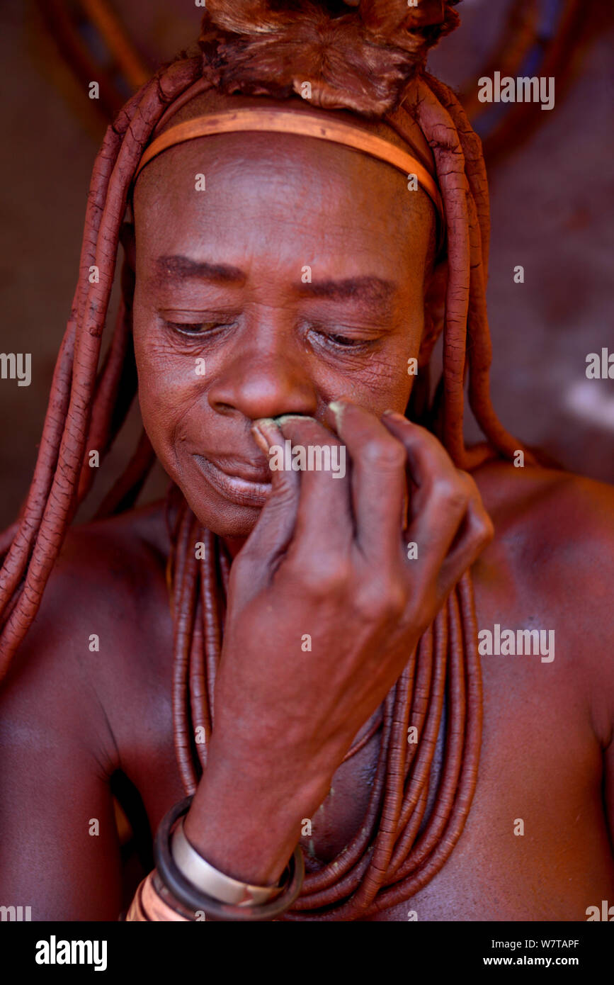 Himba woman snorting snuff tobacco. Kaokoland, Namibia, September 2013. Stock Photo