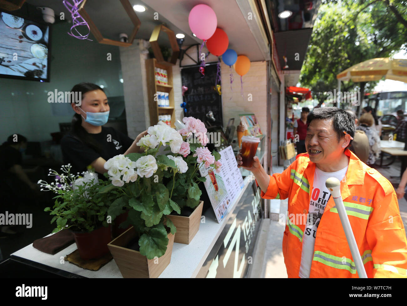 Chinese worker who buys a half-priced cold drink from a staff out of a random act of kindness is pictured at a milk-tea shop in Chengdu city, southwes Stock Photo