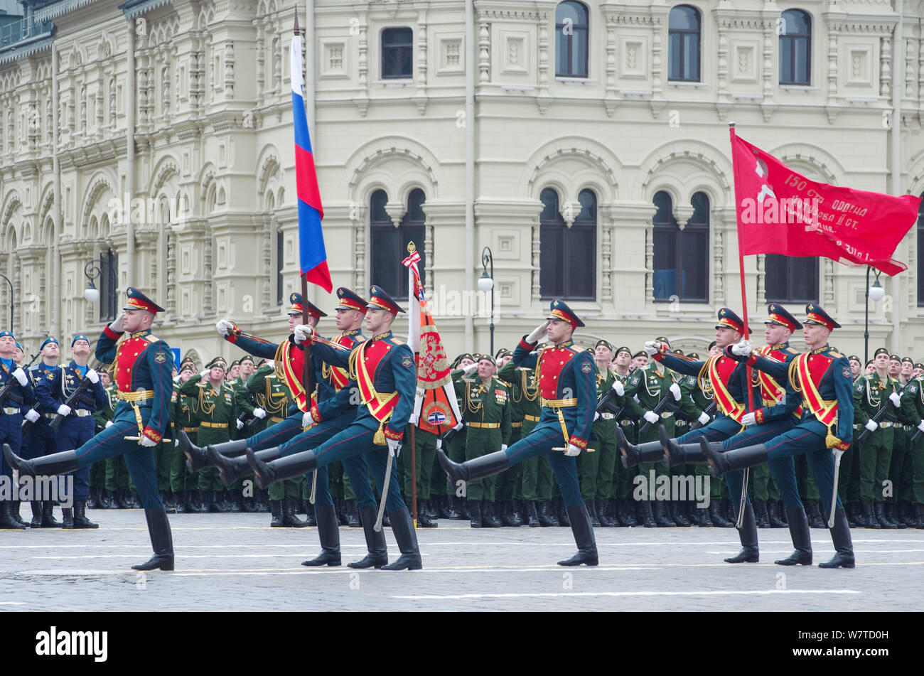 Soldiers of the 154th Preobrazhensky Independent Commandant's Regiment carry the Russian national flag and the Victory Banner marching along the Red S Stock Photo