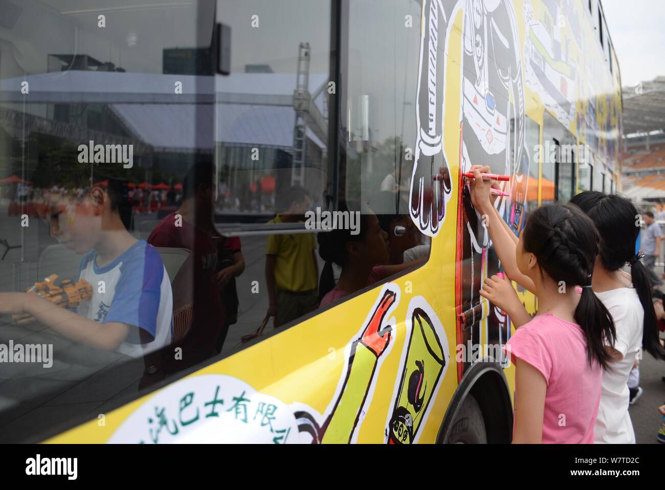 Chinese children paint a police-themed bus ahead of the International Children's Day in Guangzhou city, south China's Guangdong province, 30 May 2017. Stock Photo