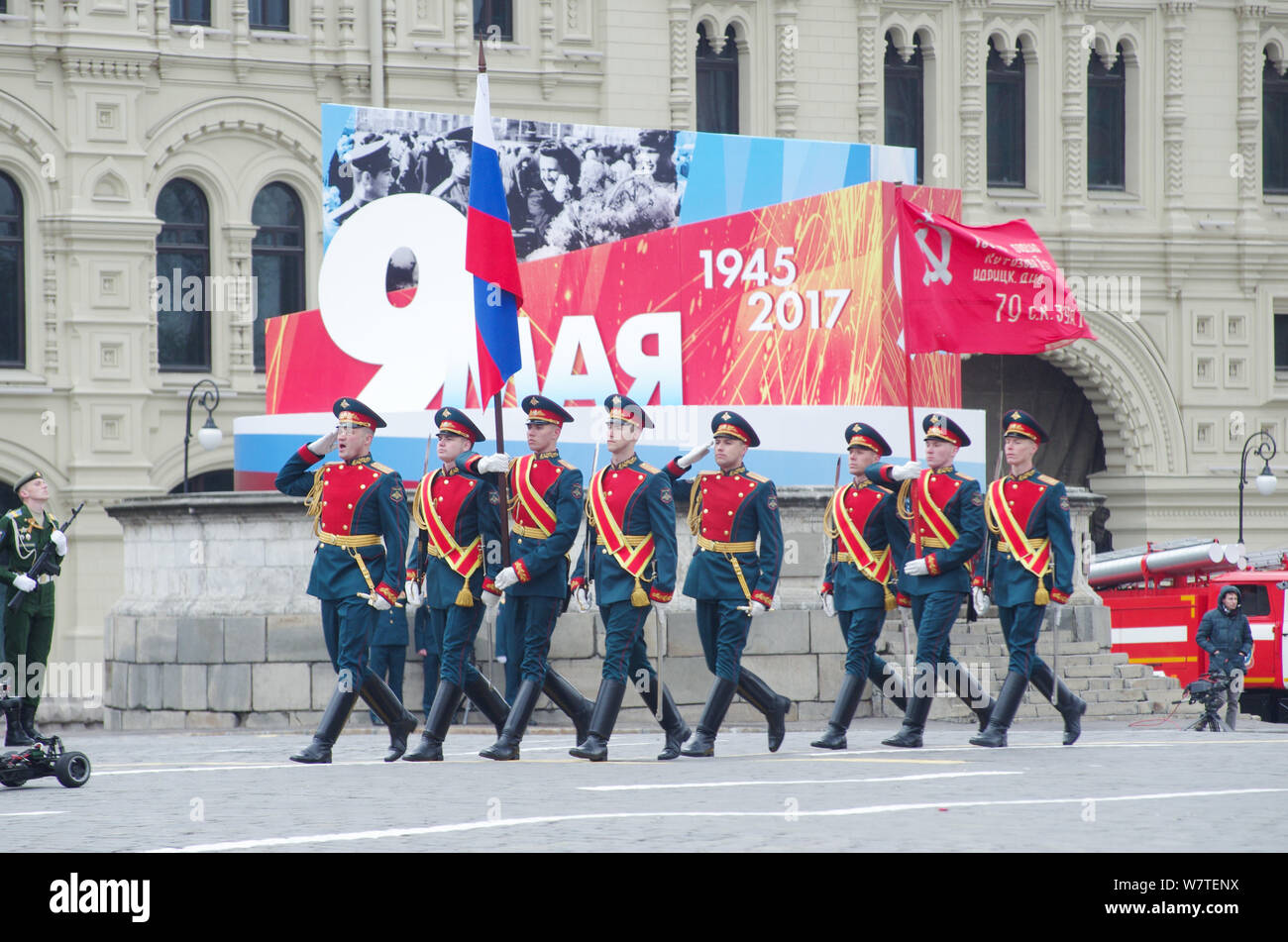 Soldiers of the 154th Preobrazhensky Independent Commandant's Regiment carry the Russian national flag and the Victory Banner marching along the Red S Stock Photo