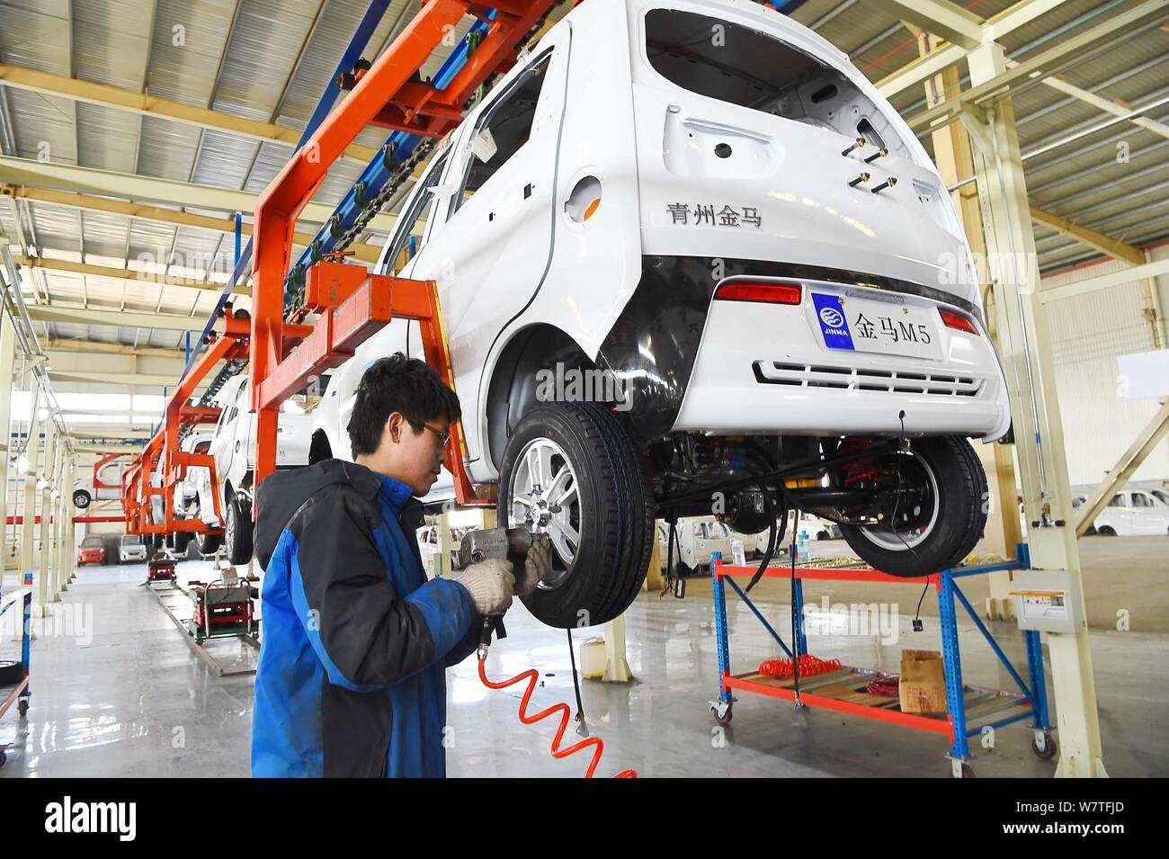 --FILE--A Chinese worker assembles an electric car on the assembly line ...