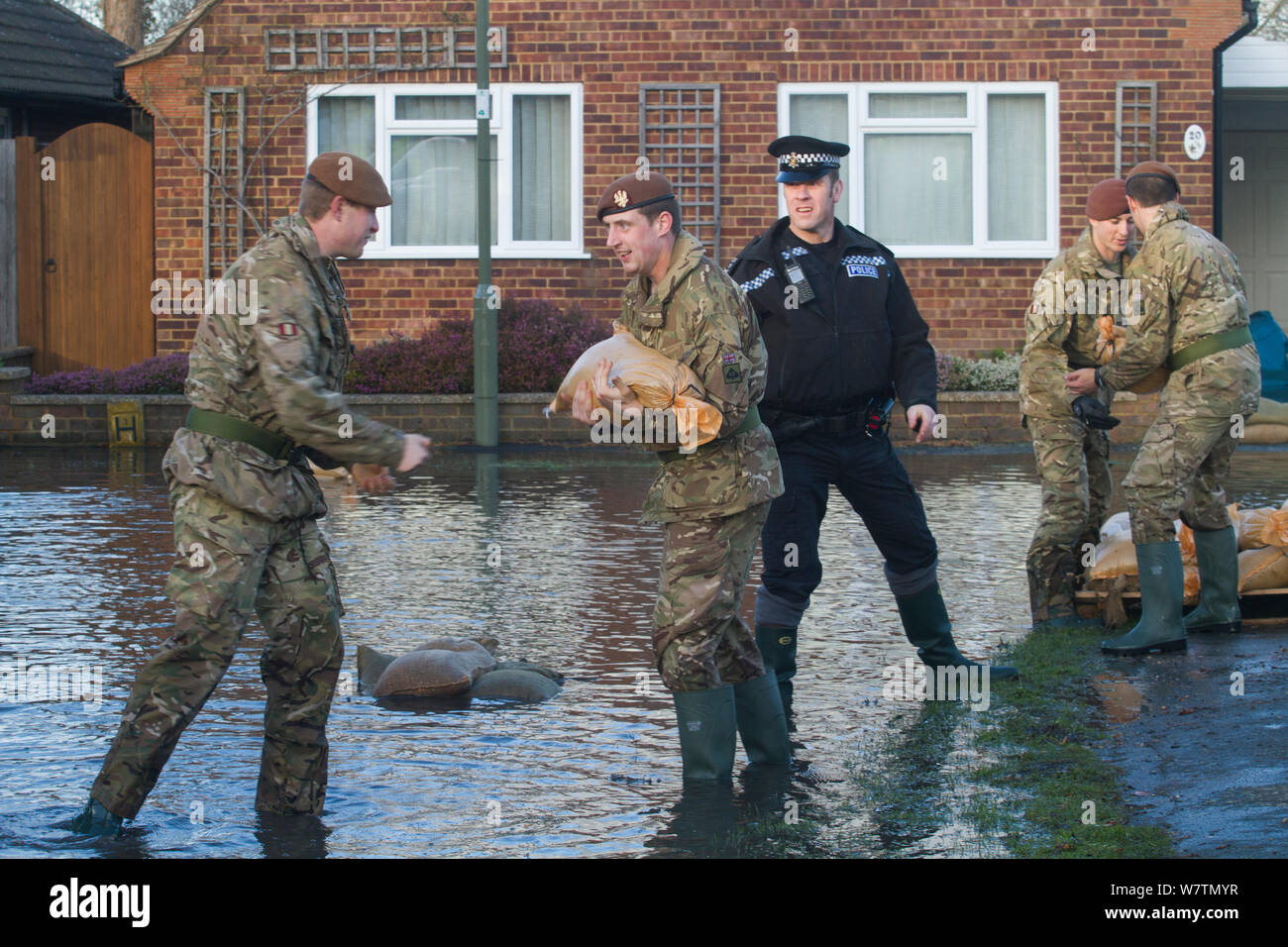 Army and police in flooded street after February 2014 flooding, helping to provide support for the residents and supplying sand bags, Chertsey, Surrey, England, UK, 16th February 2014. Stock Photo