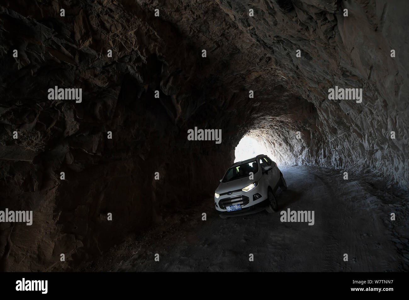 A car travels on the road carved by local villagers on the edge of a cliff on Taihang Mountains in Hongtiguan village, Pingshun county, Changzhi city, Stock Photo
