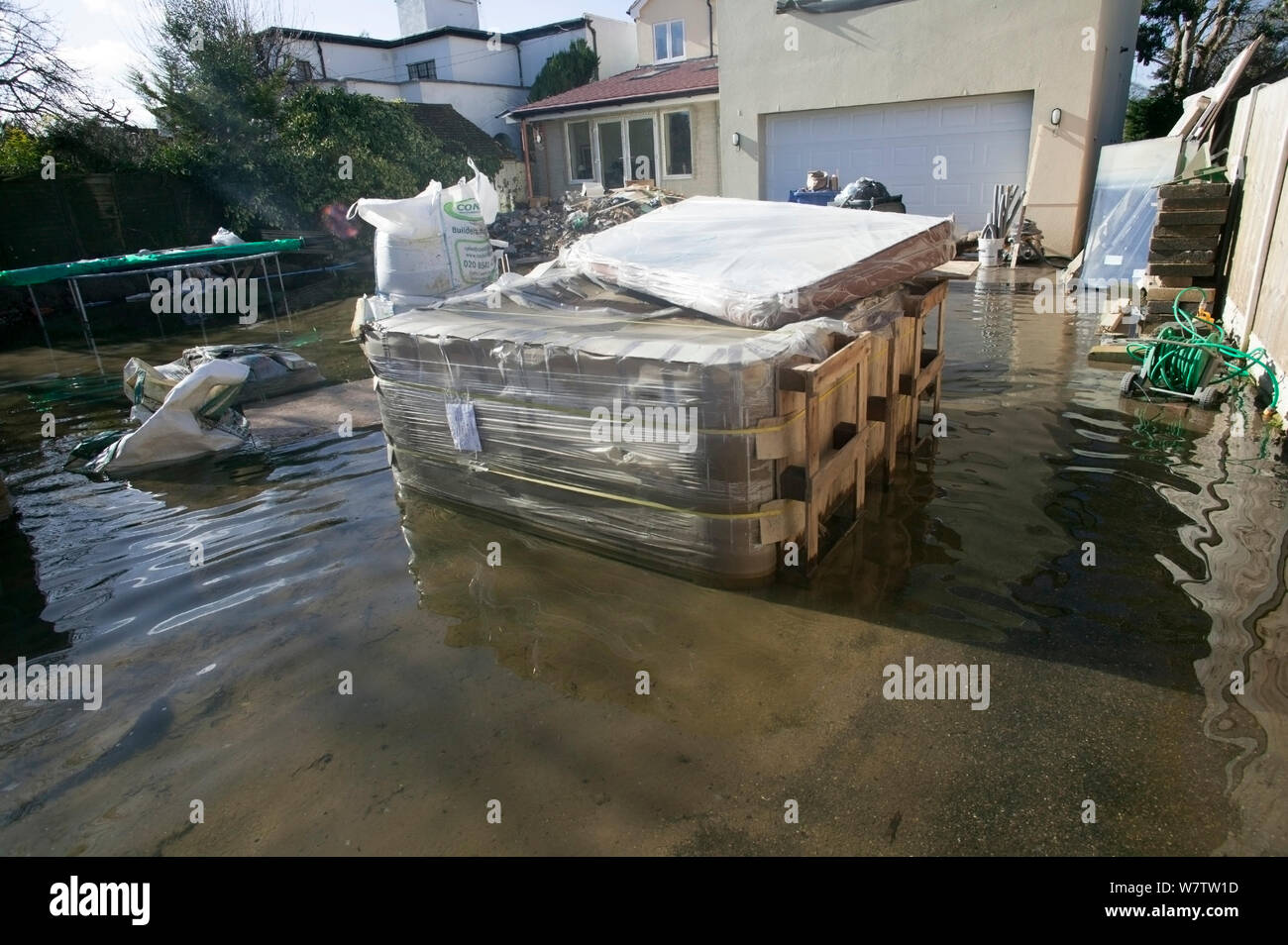 Building materials in flood water outside new home during February 