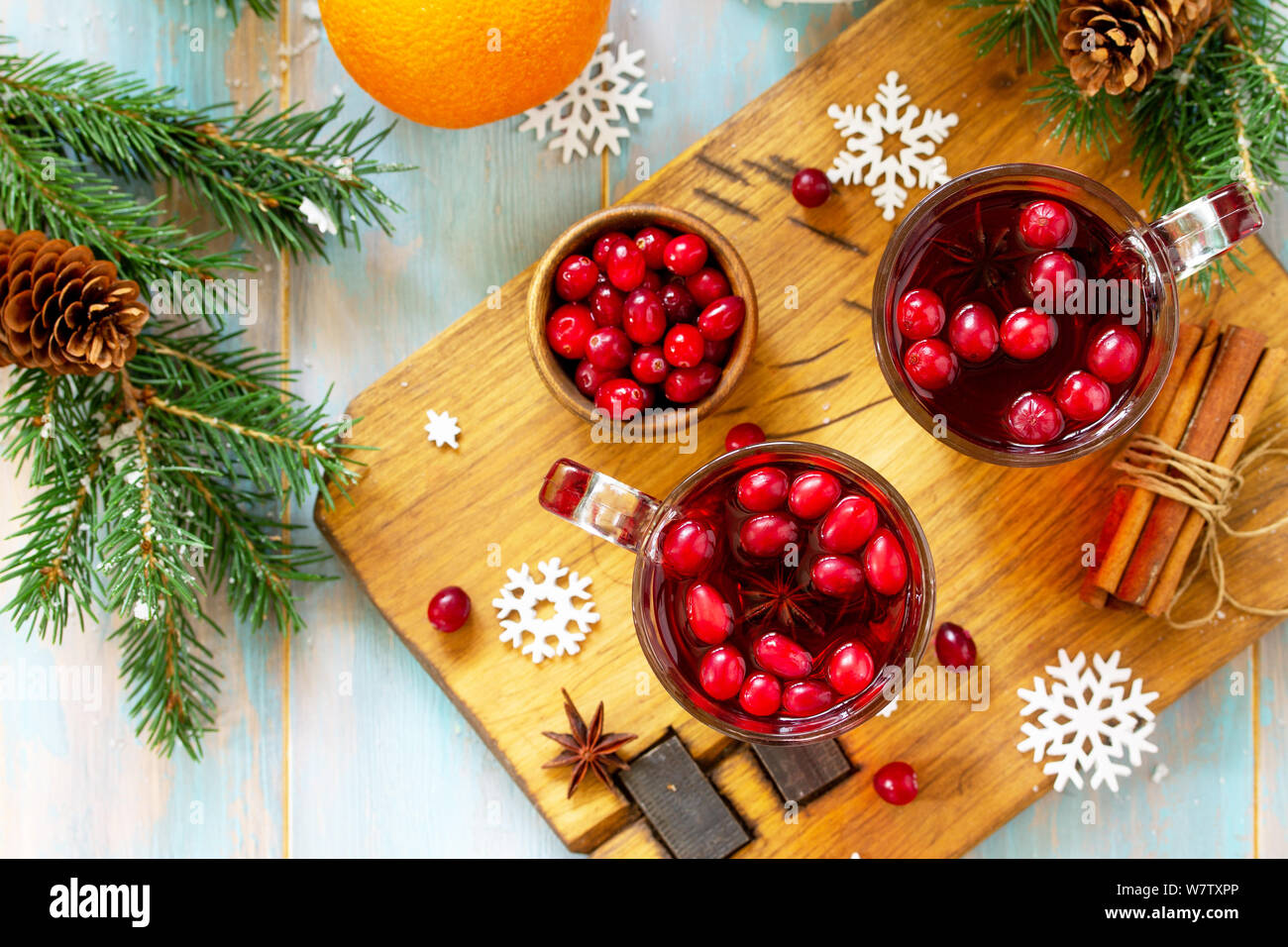 Christmas, Thanksgiving drinks. Hot winter drink with cranberries and cinnamon on wooden table. Top view flat lay with copy space for your text. Stock Photo