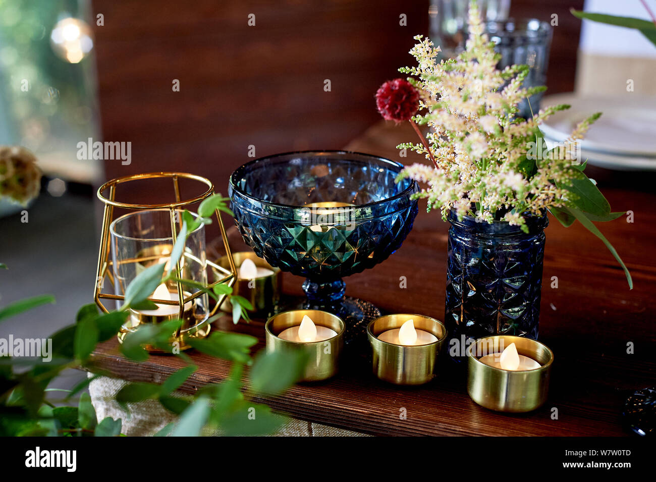 Decoration table newlyweds, blue dishes, bottles of flowers and candles.Wedding floristry. Stock Photo