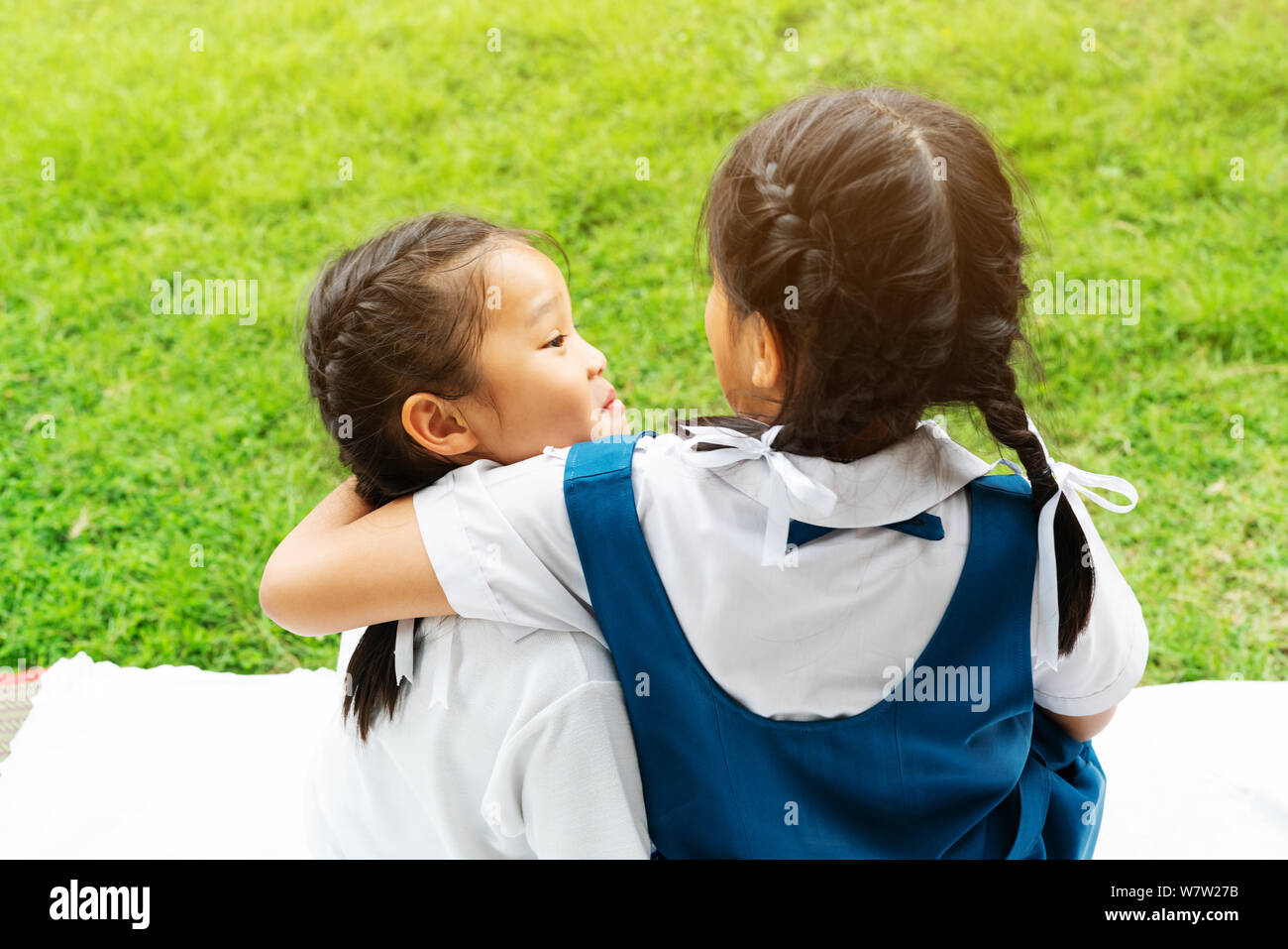 two little asian girls sisters hugging happy post in school uniform ...