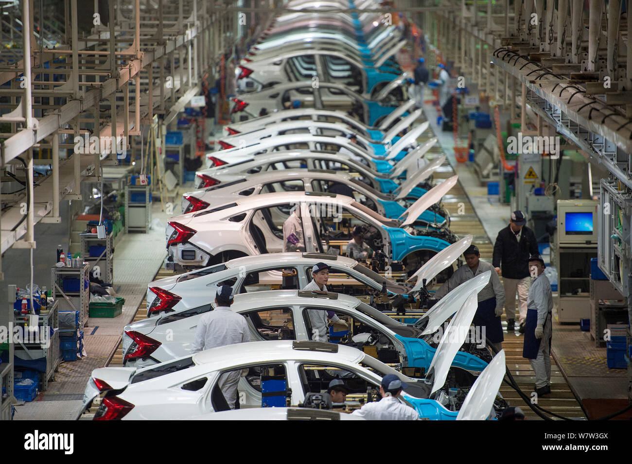 --FILE--Chinese workers assemble cars on the assembly line at an auto ...