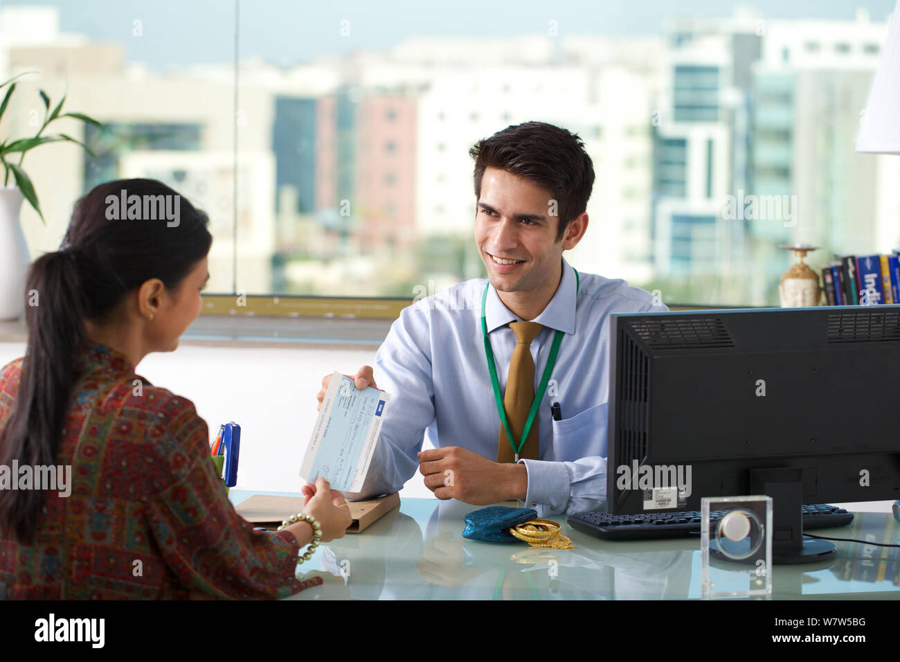 Bank manager giving loan cheque to a client Stock Photo - Alamy
