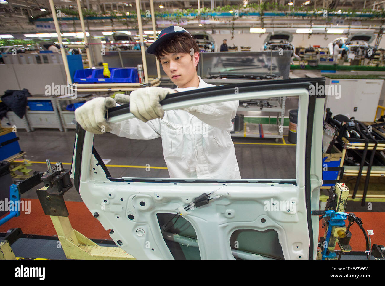 --FILE--A Chinese worker assembles a car on the assembly line at an ...