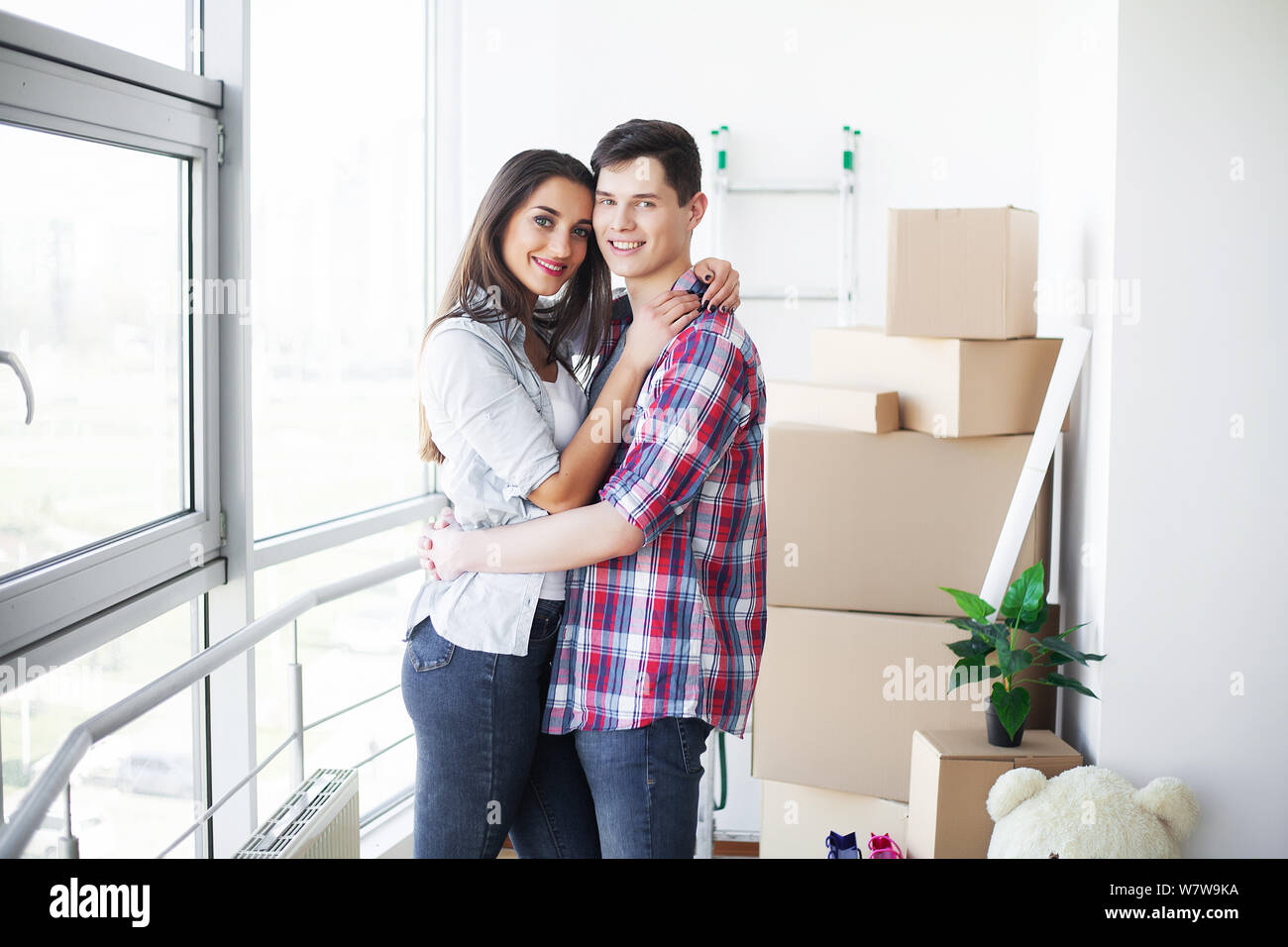 Nnew a apartment. Happy couple in their new home. Young couple hugging ...