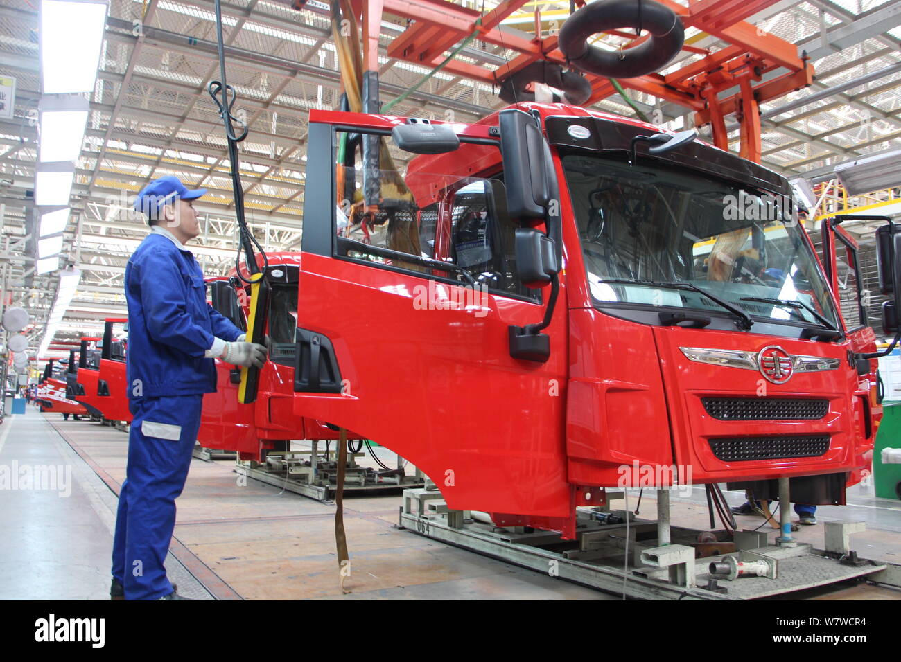 --FILE--A Chinese worker assembles trucks on the assembly line at an ...