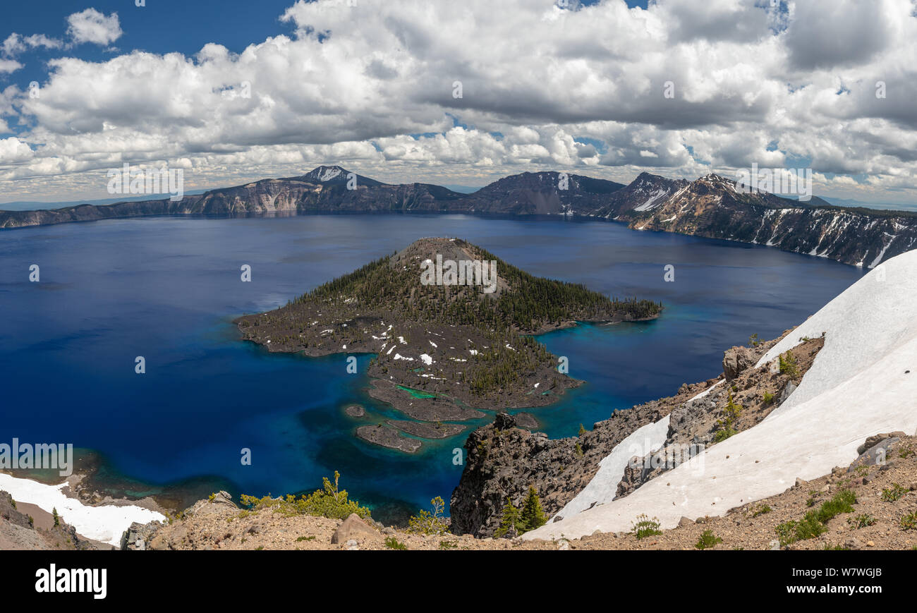 This is the picture of Wizard Island at Crater Lake National Park with clouds and blue sky Stock Photo