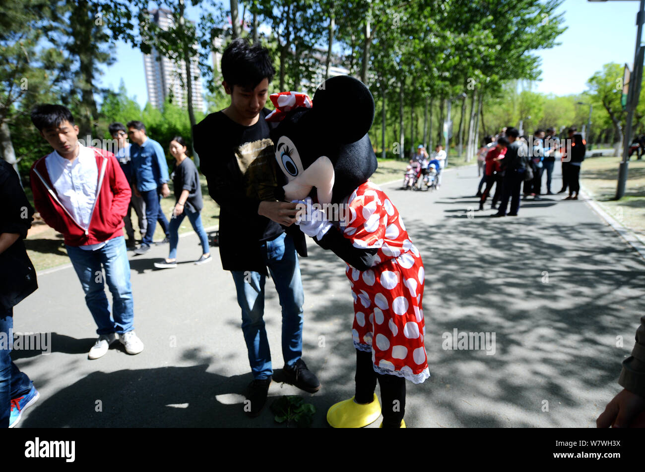 Elderly Chinese woman Yin Pizhi in her 70s, who plays Minnie Mouse to raise money for the treatment of her daughter-in-law, seeks visitors willing to Stock Photo