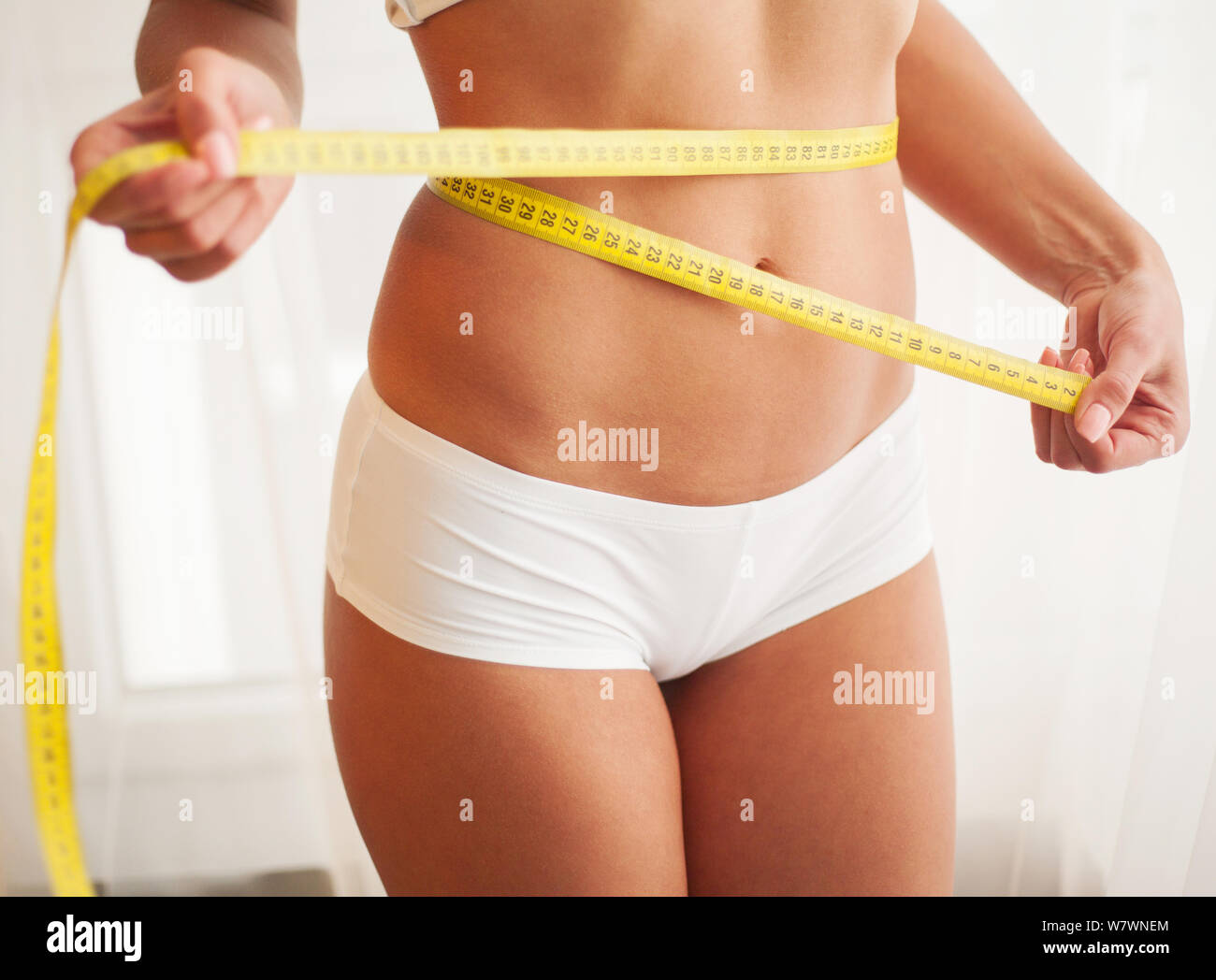 Woman with measuring tape. Weight loss concept. Woman take waist scale tape  show her thin waist. Slim girl with centimeter. Closeup woman measuring  Stock Photo - Alamy