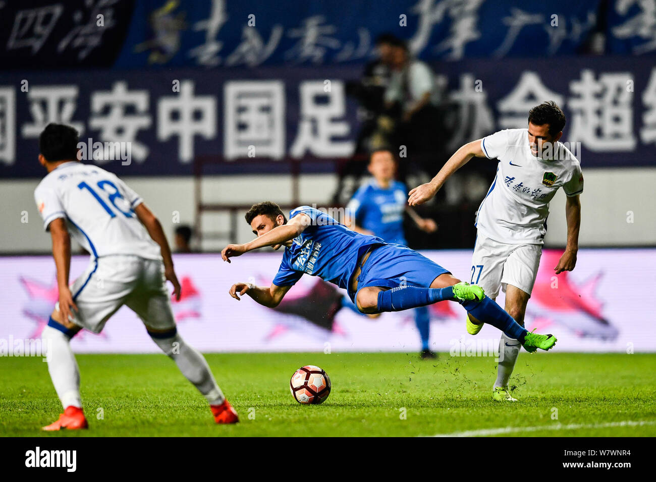 Greek Australian football player Apostolos Giannou of Guangzhou R&F, center, challenges Australian football player Ryan McGowan of Guizhou Zhicheng in Stock Photo