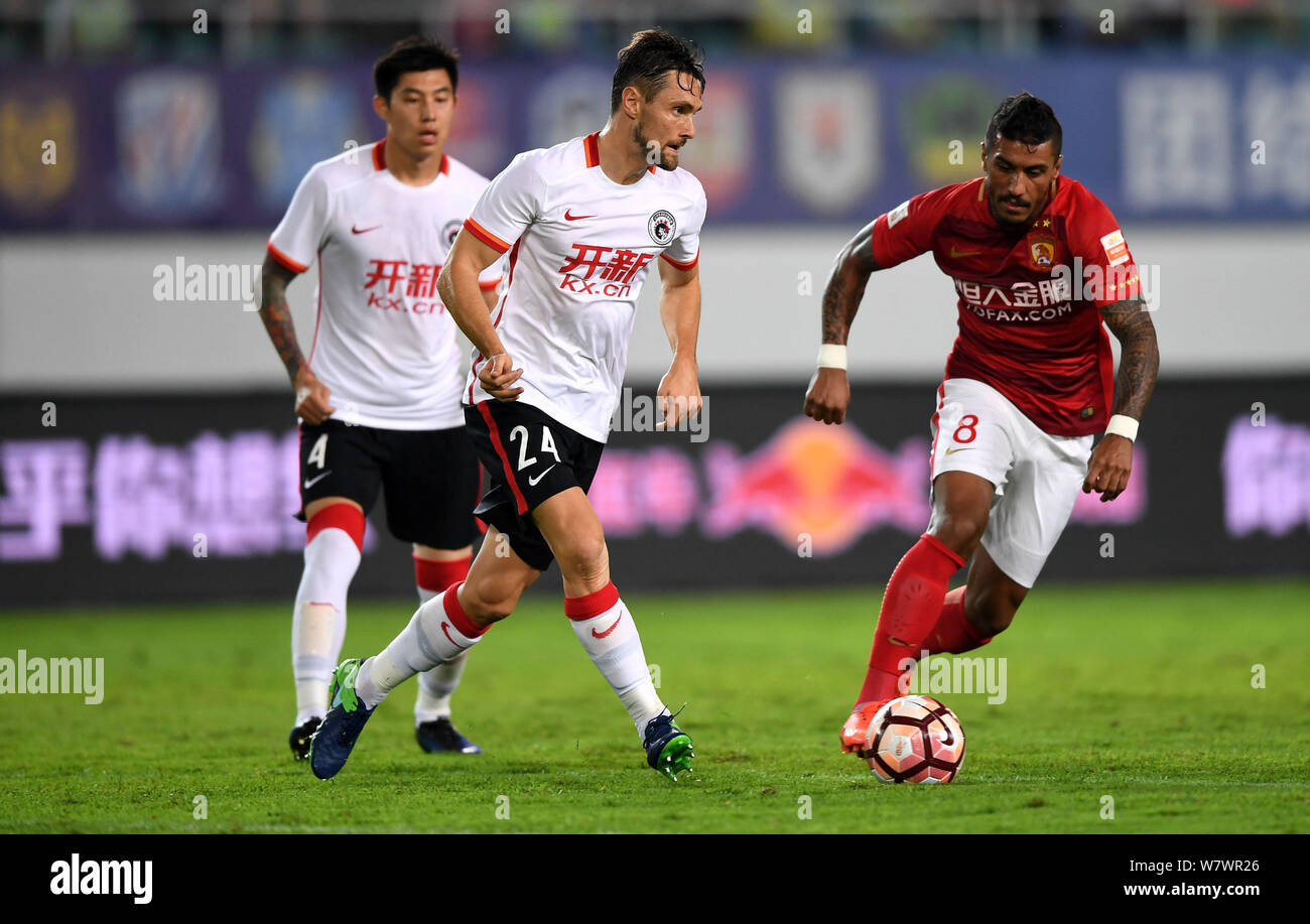 Brazilian football player Paulinho of Guangzhou Evergrande Taobao, right, challenges with Australian football player James Holland, center, of Liaonin Stock Photo
