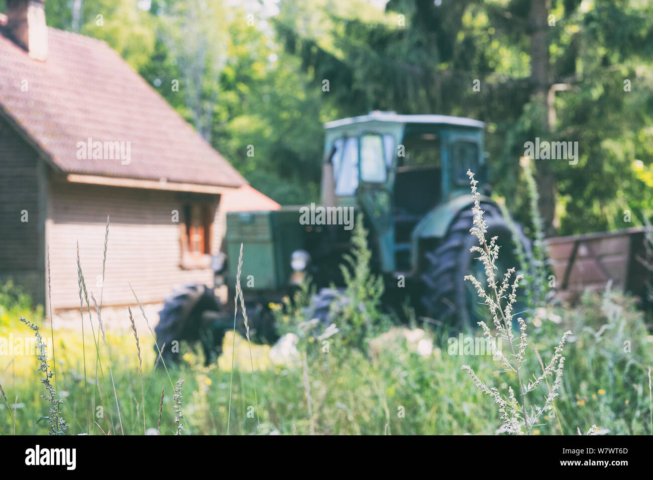 A tractor stands at a rural house Stock Photo