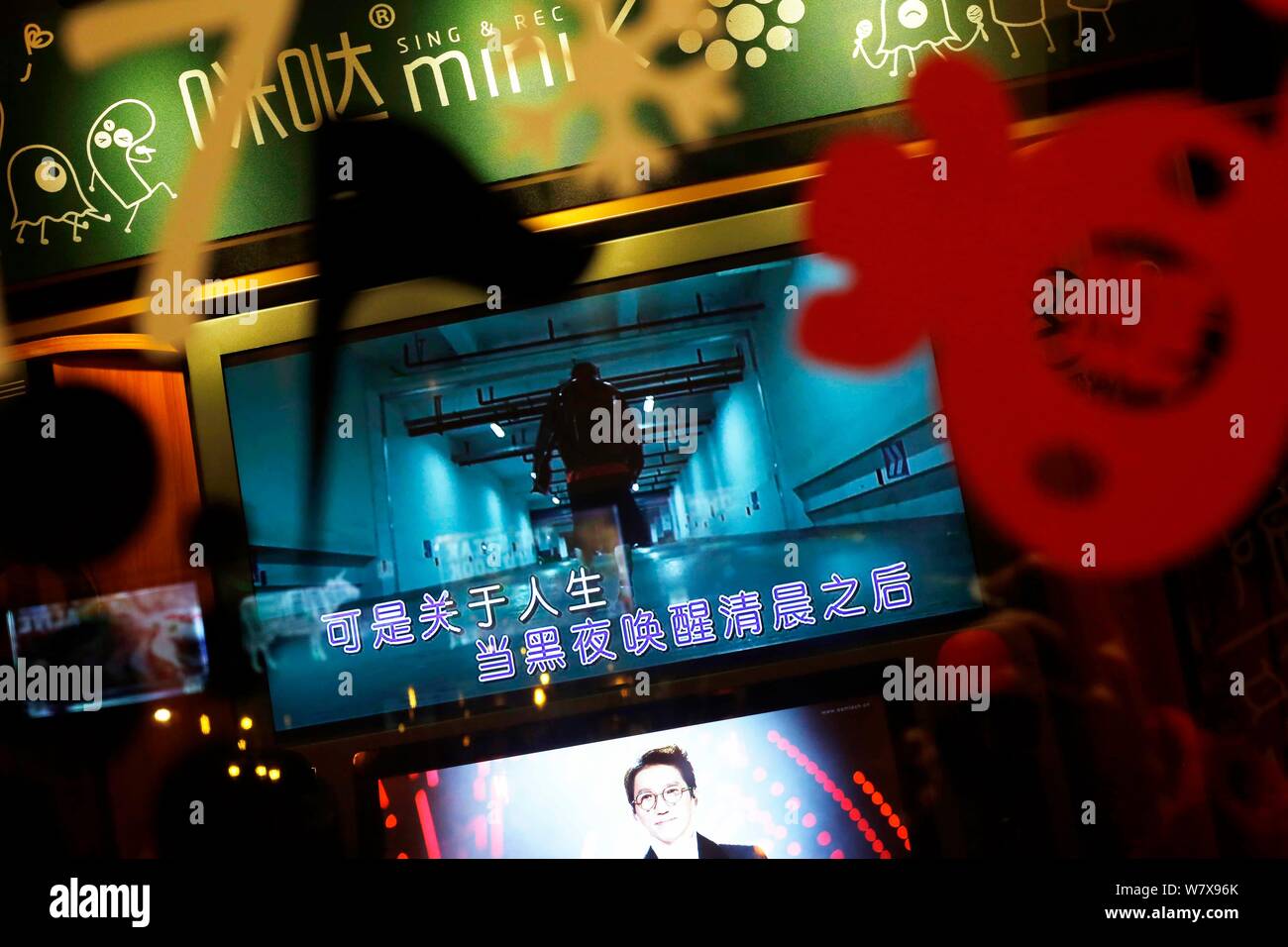 --FILE--Chinese customers sing at a mini karaoke booth in the basement ...