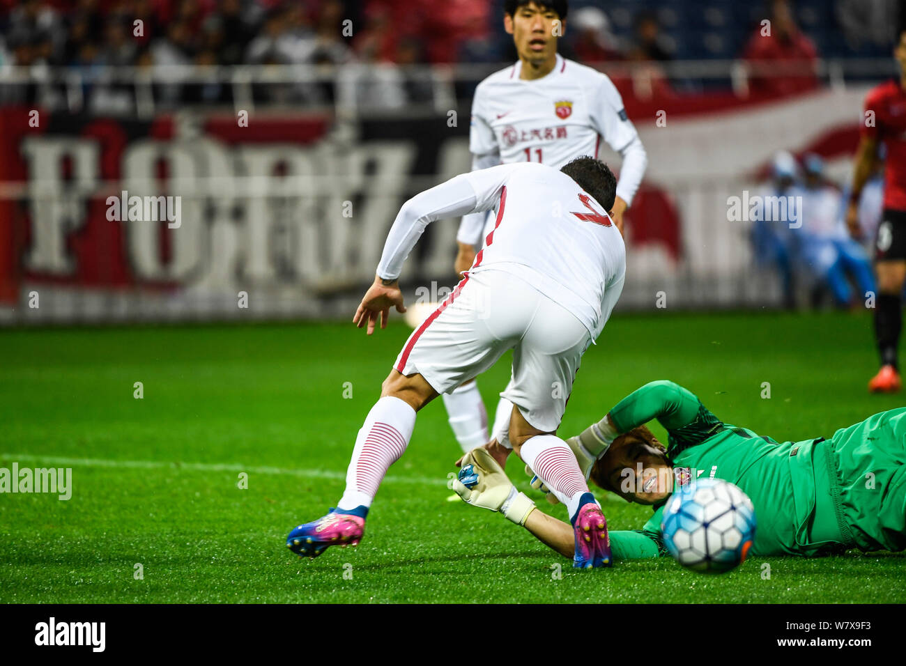 Brazilian football player Elkeson of China's Shanghai SIPG, left, challenges Shusaku Nishikawa of Japan's Urawa Red Diamonds in their Group F match du Stock Photo