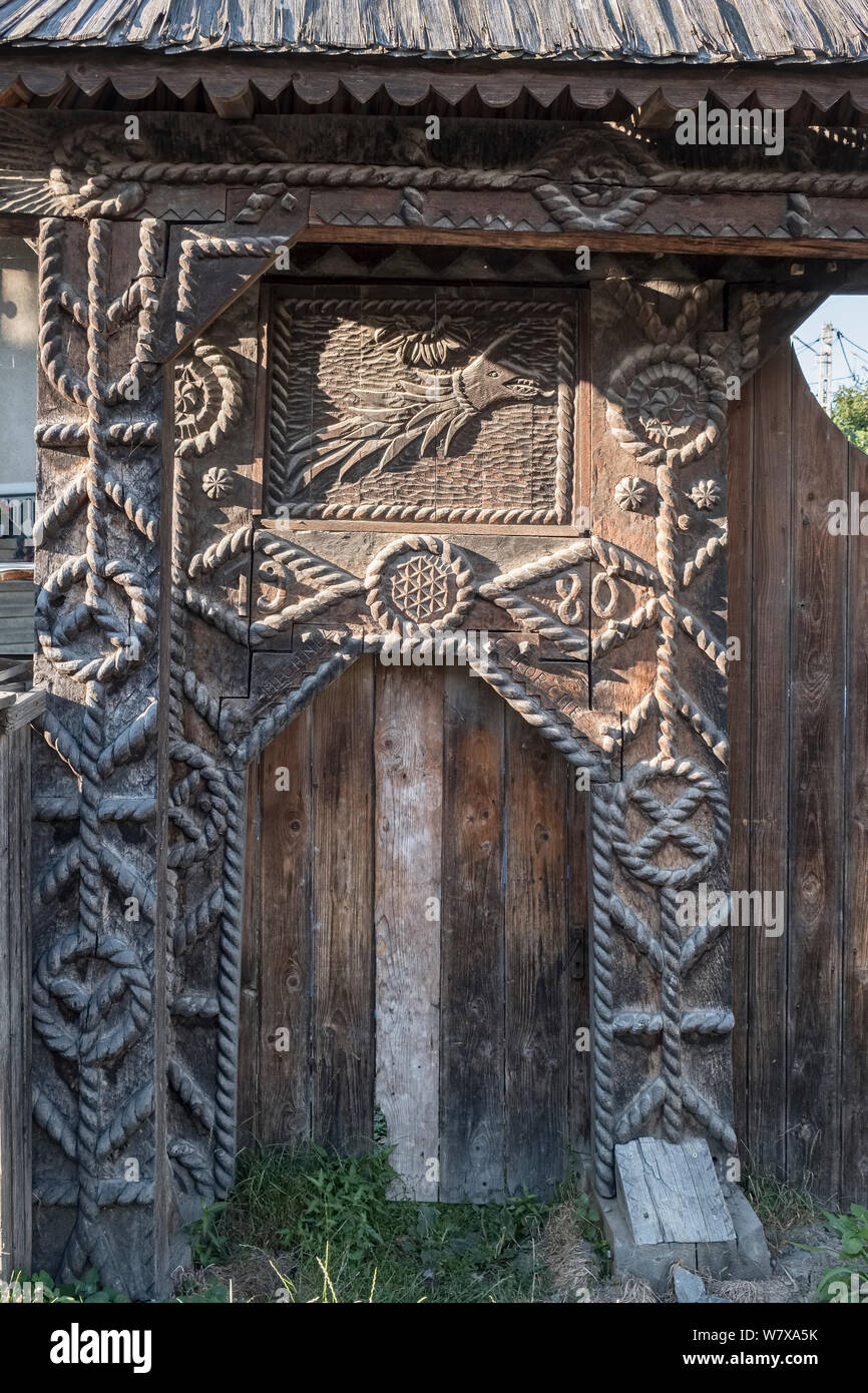 Botiza, Maramureș, Romania. Elaborately carved wooden gates outside village houses are a feature of the region Stock Photo